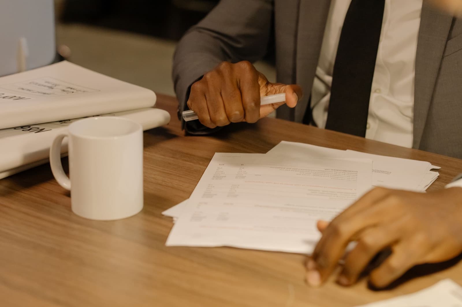 Hands reviewing printed documents at a desk